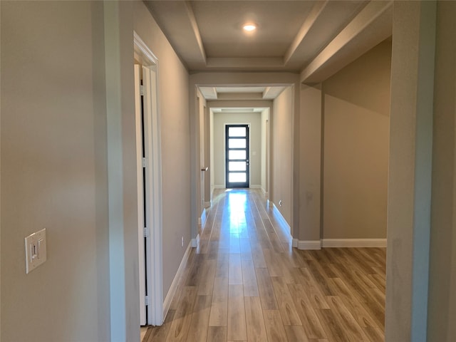 hall featuring a raised ceiling and light wood-type flooring