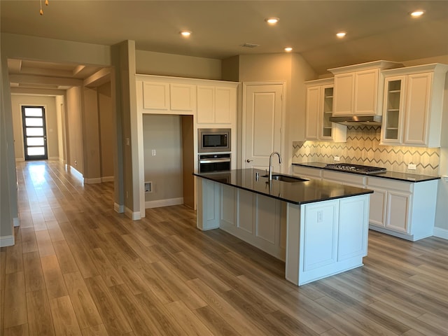 kitchen with white cabinetry, appliances with stainless steel finishes, sink, and a center island with sink