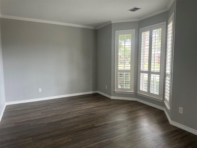 spare room with dark wood-style floors, baseboards, visible vents, and crown molding