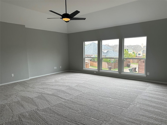 carpeted spare room featuring vaulted ceiling, a ceiling fan, and baseboards