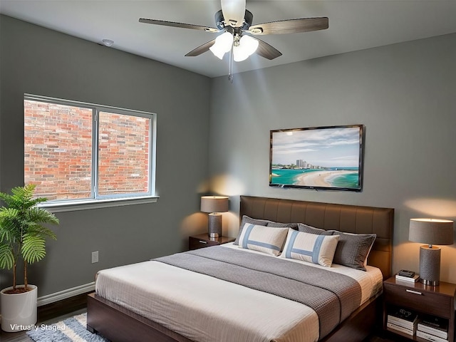 bedroom featuring a ceiling fan, baseboards, and wood finished floors