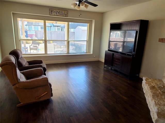 sitting room with a healthy amount of sunlight, dark wood-type flooring, and ceiling fan