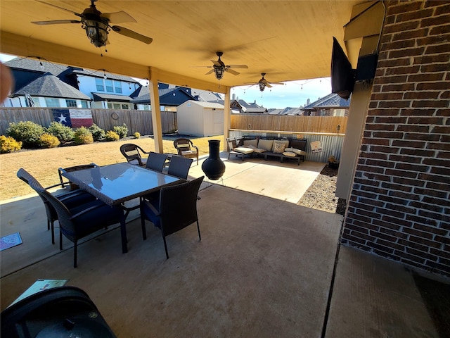 view of patio / terrace featuring an outdoor living space, ceiling fan, and a storage unit