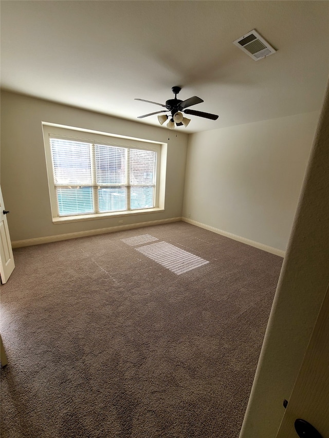 empty room featuring ceiling fan and carpet