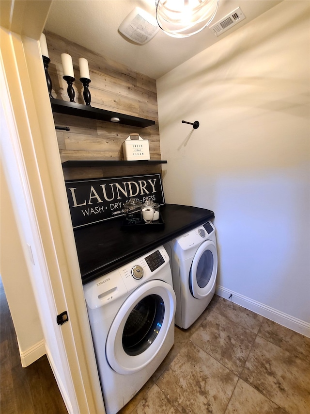 washroom with washer and clothes dryer and wood walls