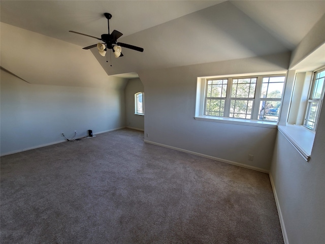 bonus room with dark carpet, vaulted ceiling, and ceiling fan