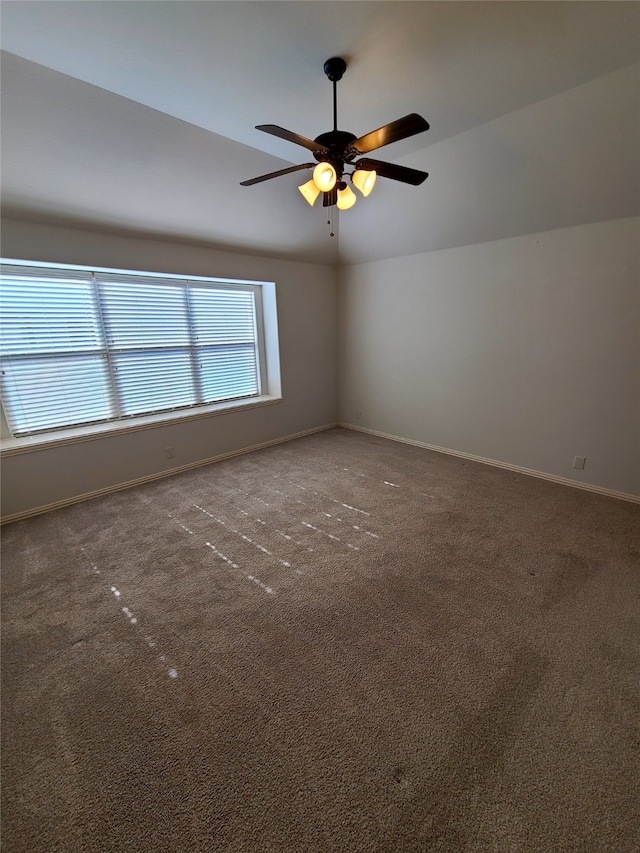 spare room featuring lofted ceiling, carpet flooring, and ceiling fan