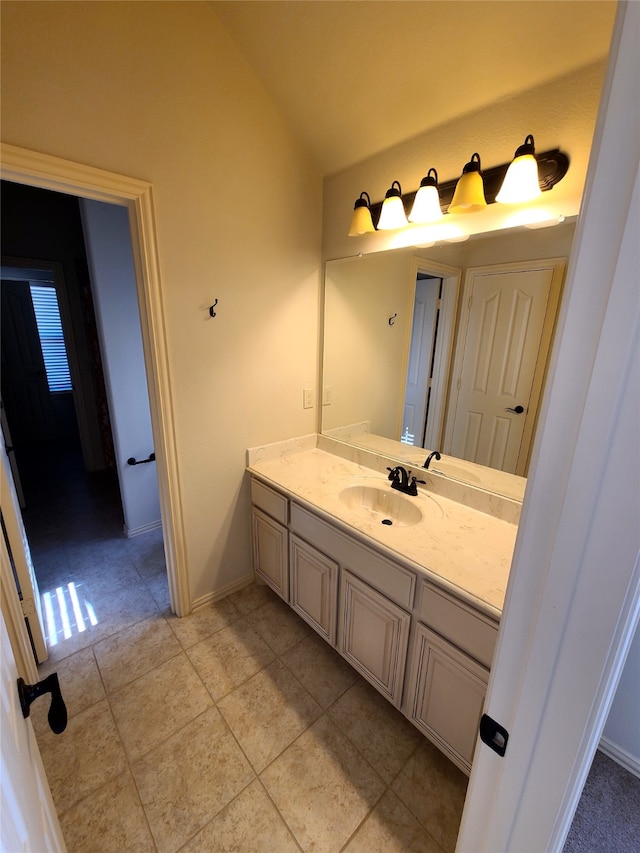 bathroom with lofted ceiling, vanity, and tile patterned floors