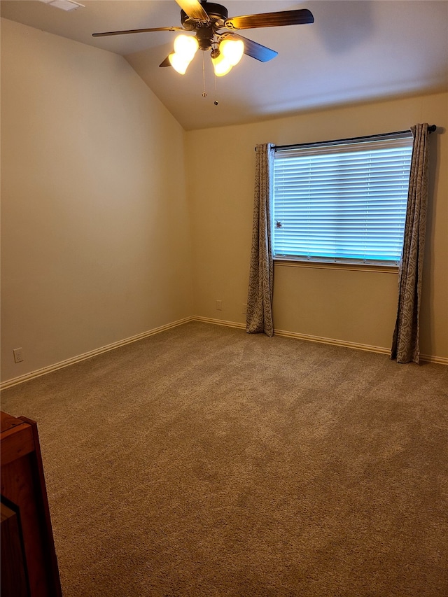 spare room featuring ceiling fan, vaulted ceiling, and carpet