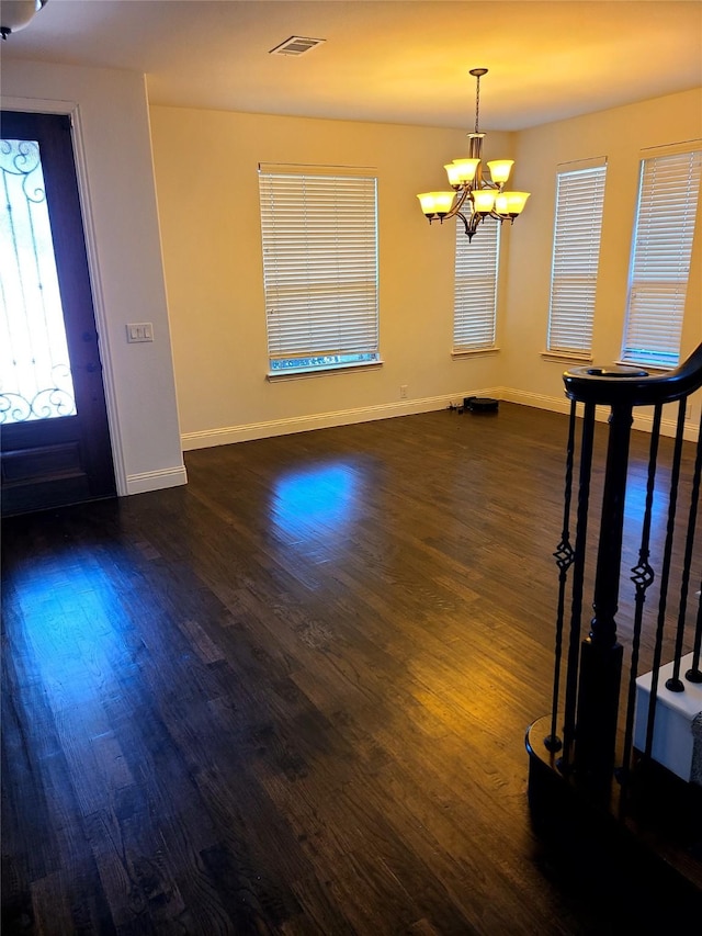 foyer with an inviting chandelier and dark hardwood / wood-style floors