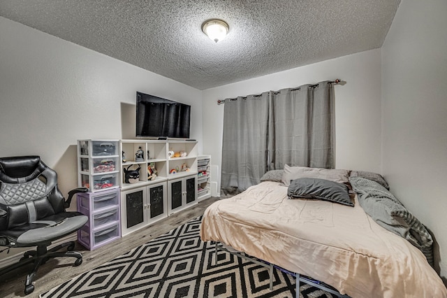 bedroom with hardwood / wood-style flooring and a textured ceiling