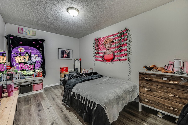 bedroom with hardwood / wood-style floors and a textured ceiling