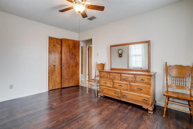 bedroom featuring ceiling fan, dark hardwood / wood-style floors, and a textured ceiling