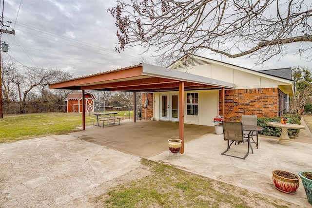 view of patio with french doors and a shed