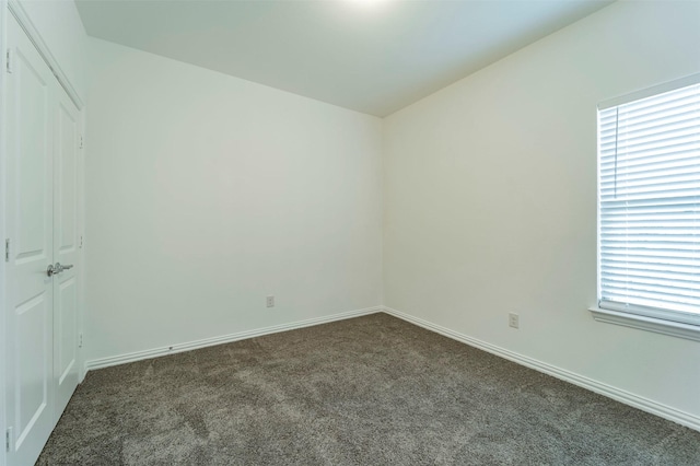 empty room with dark colored carpet