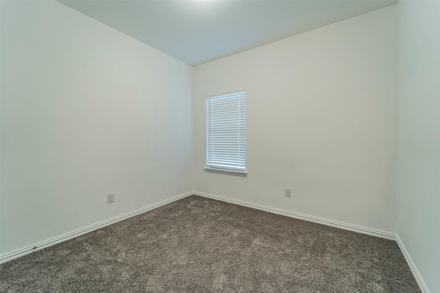 unfurnished room featuring dark carpet