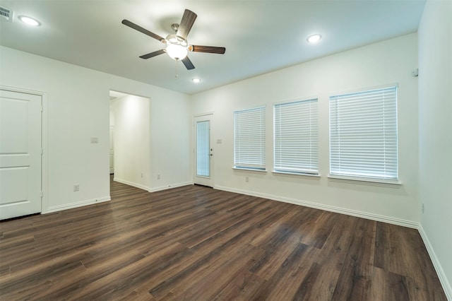 spare room featuring dark wood-type flooring and ceiling fan