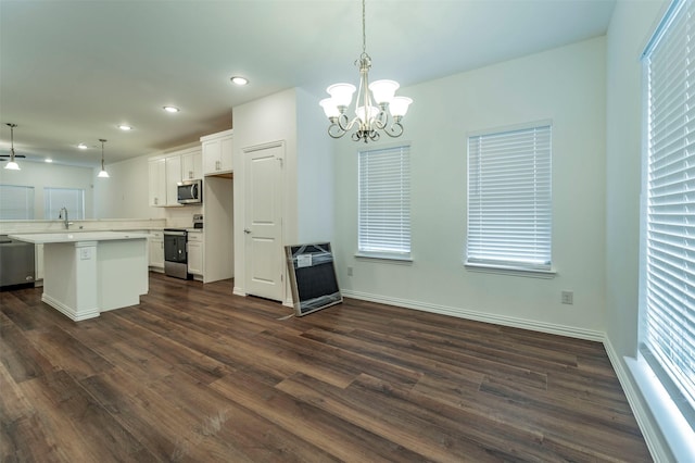 kitchen featuring dark wood-type flooring, sink, decorative light fixtures, stainless steel appliances, and white cabinets