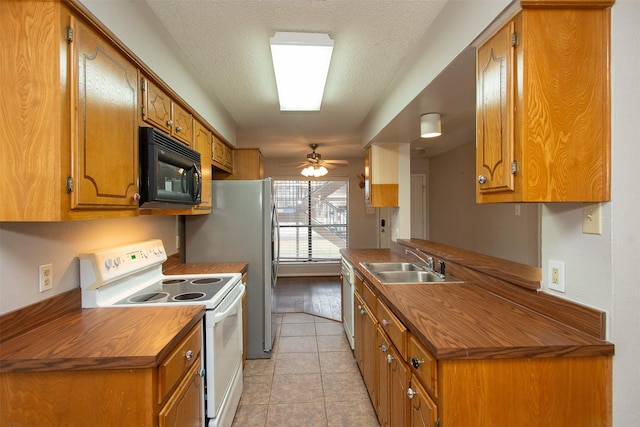 kitchen with sink, white appliances, light tile patterned floors, ceiling fan, and a textured ceiling