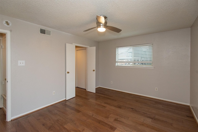 unfurnished room featuring wood finished floors, a ceiling fan, visible vents, baseboards, and a textured ceiling