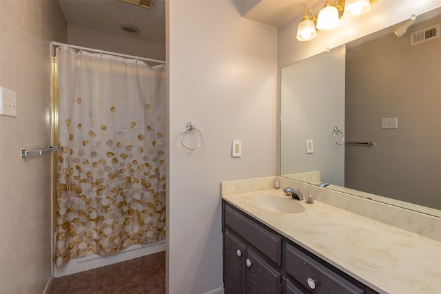 full bath featuring visible vents, a shower with curtain, vanity, and a textured ceiling