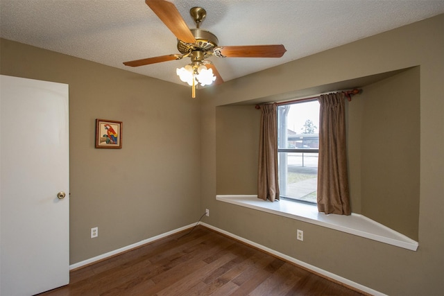 spare room featuring baseboards, a textured ceiling, ceiling fan, and dark wood-style flooring