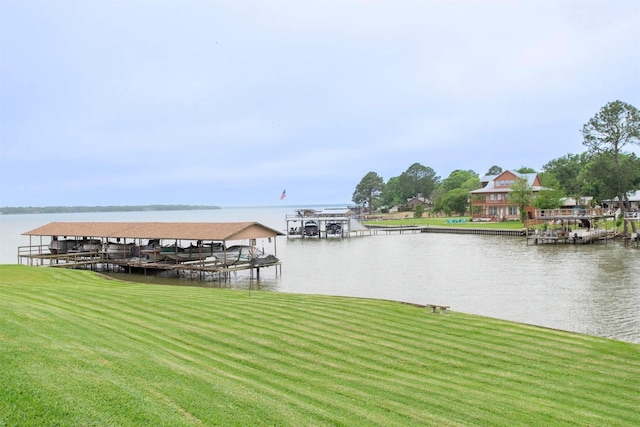 view of dock with a water view and a lawn