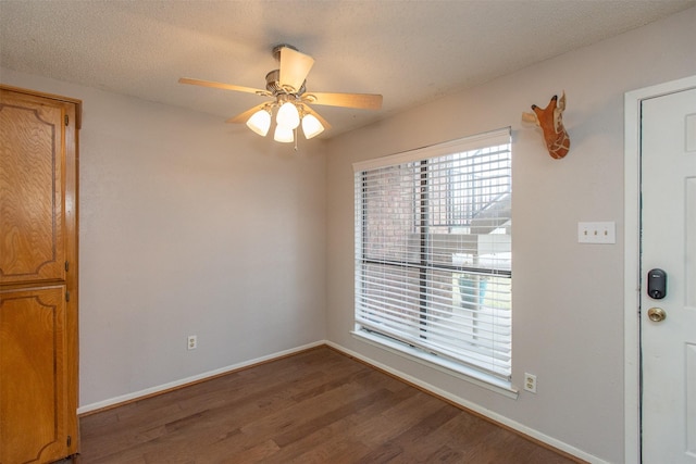 unfurnished room featuring ceiling fan, baseboards, a textured ceiling, and wood finished floors