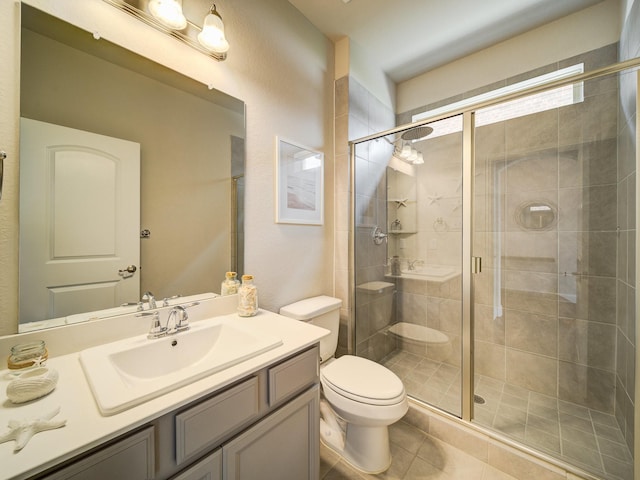 bathroom with walk in shower, tile patterned floors, vanity, and toilet