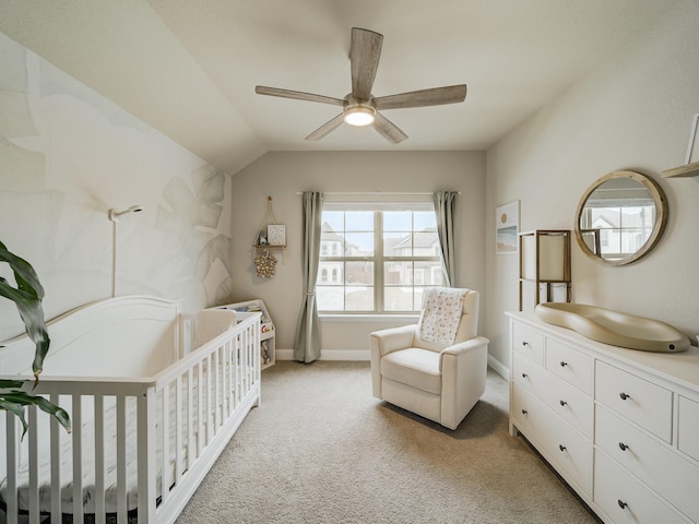 bedroom with a nursery area, ceiling fan, lofted ceiling, and light carpet