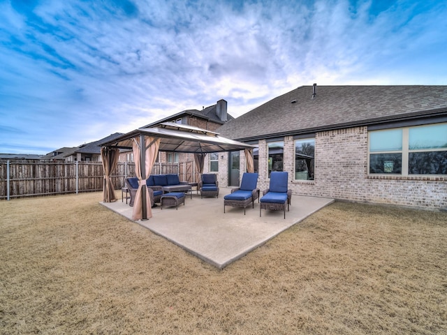 back of property with a gazebo, an outdoor hangout area, a patio area, and a lawn