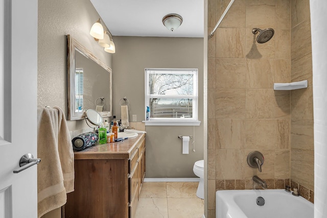 full bathroom featuring tiled shower / bath, vanity, and toilet