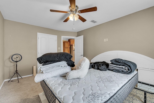 bedroom with ceiling fan, a closet, and light carpet