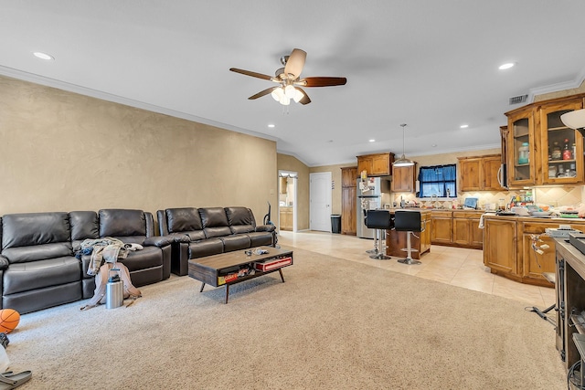 carpeted living room featuring ornamental molding, vaulted ceiling, and ceiling fan