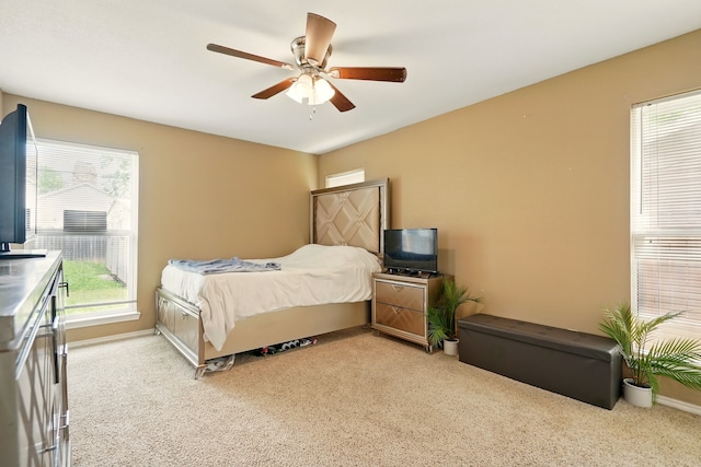 bedroom with light carpet, ceiling fan, and baseboards