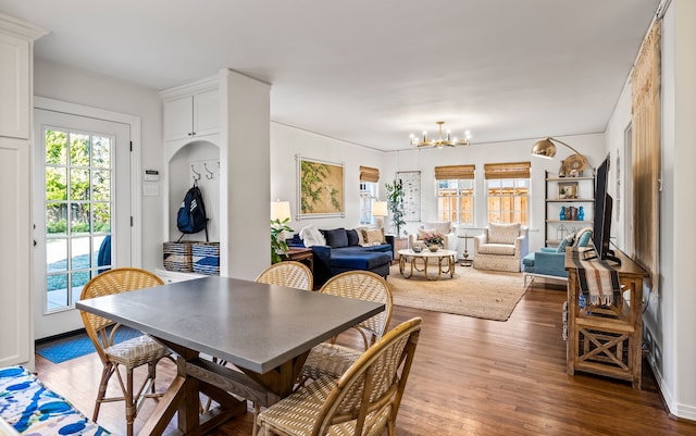 dining room with plenty of natural light, dark wood-type flooring, and a notable chandelier