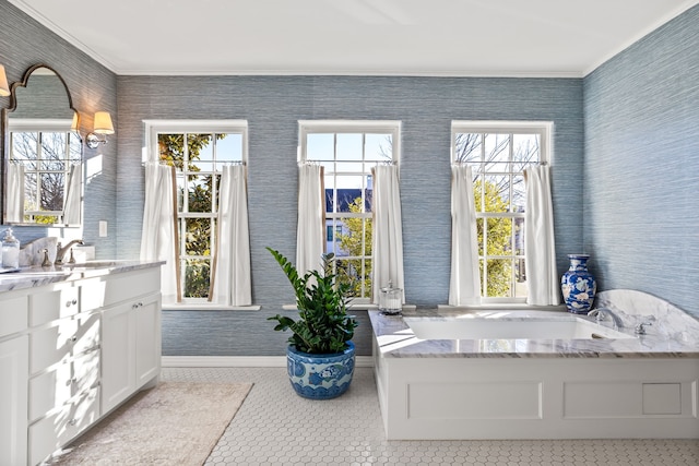 bathroom with a healthy amount of sunlight, tile patterned floors, a bathtub, and vanity