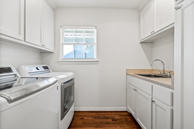 clothes washing area with cabinets, dark hardwood / wood-style flooring, sink, and washer and clothes dryer