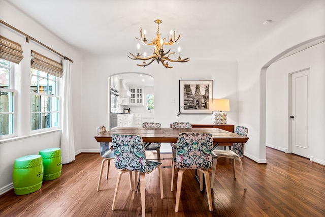 dining area featuring hardwood / wood-style flooring and an inviting chandelier