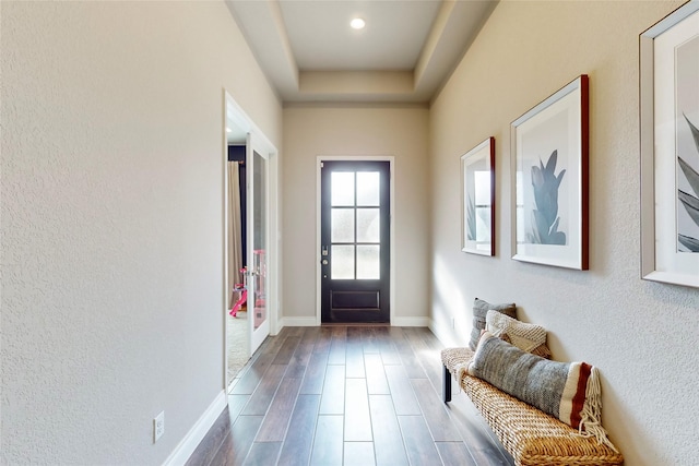 doorway featuring a raised ceiling and hardwood / wood-style floors