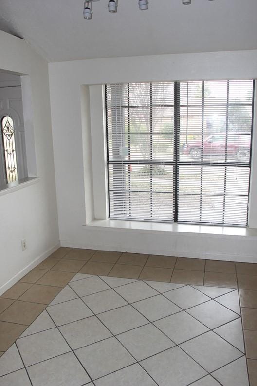 9514 Zelkova Cir, Dallas, TX 75249 - unfurnished room with plenty of natural light, baseboards, and light tile patterned floors