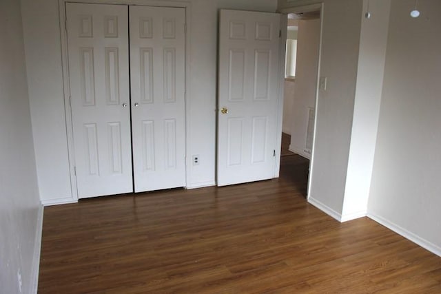 9514 Zelkova Cir, Dallas, TX 75249 - unfurnished bedroom featuring a closet, baseboards, and wood finished floors