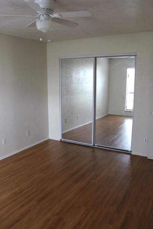 9514 Zelkova Cir, Dallas, TX 75249 - unfurnished bedroom featuring baseboards, ceiling fan, and wood finished floors