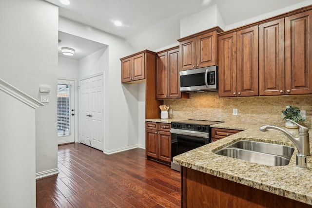 kitchen featuring range with electric cooktop, a sink, stainless steel microwave, light stone countertops, and backsplash