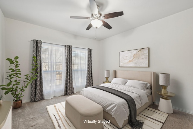 bedroom featuring light carpet, ceiling fan, and baseboards