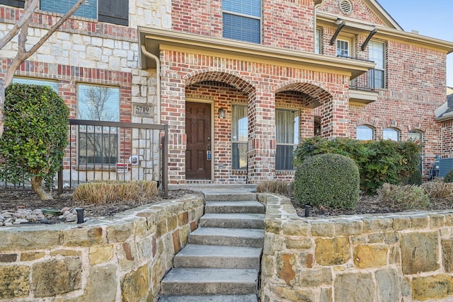 view of exterior entry featuring brick siding