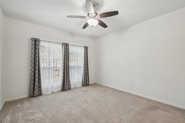 empty room featuring carpet, baseboards, and ceiling fan