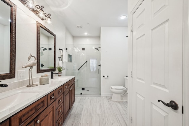 bathroom with a sink, toilet, double vanity, and a stall shower