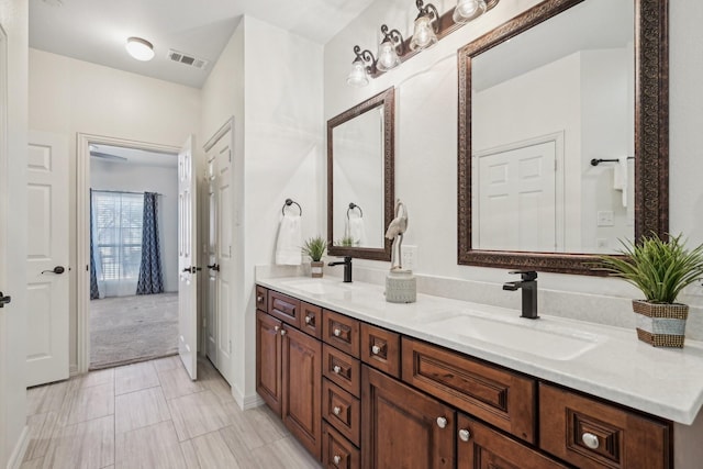 bathroom with visible vents, a sink, and double vanity