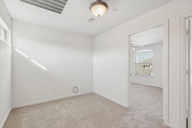 unfurnished room with baseboards, visible vents, a ceiling fan, and light colored carpet